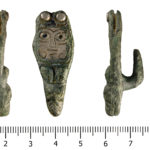 An Early medieval zoomorphic copper alloy strap end with a silver rivet, and a hook attachment on the reverse.