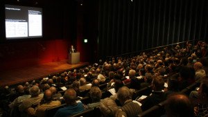 A speaker at a podium in the BP lecture theatre at the British Museum talking to a conference crowd