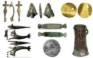 Image of 7 artefacts found in the Avon area. Top row from left to right: Roman brooch, flint arrow head, gold coin of Charles I with pierced hole. Bottom row left to right: bronze figurine of a Capricorn, copper alloy and gold mount for a horse bridle, silver coin of Edward I, copper alloy axe head.